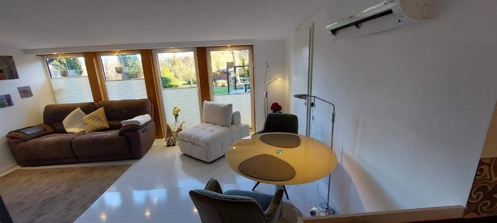a living room with a table and a couch at Gartencharlet in Extertal