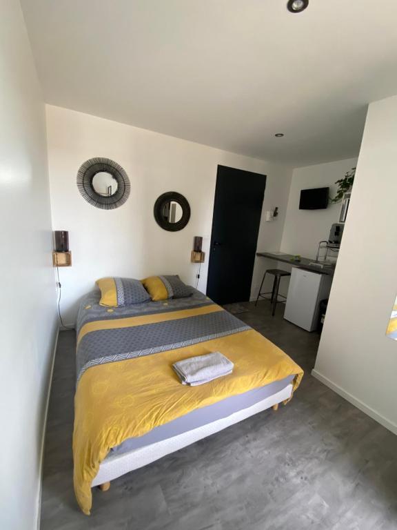 een slaapkamer met een bed met een geel dekbed bij Studio Chambre St Genest Malifaux in Saint-Genest-Malifaux