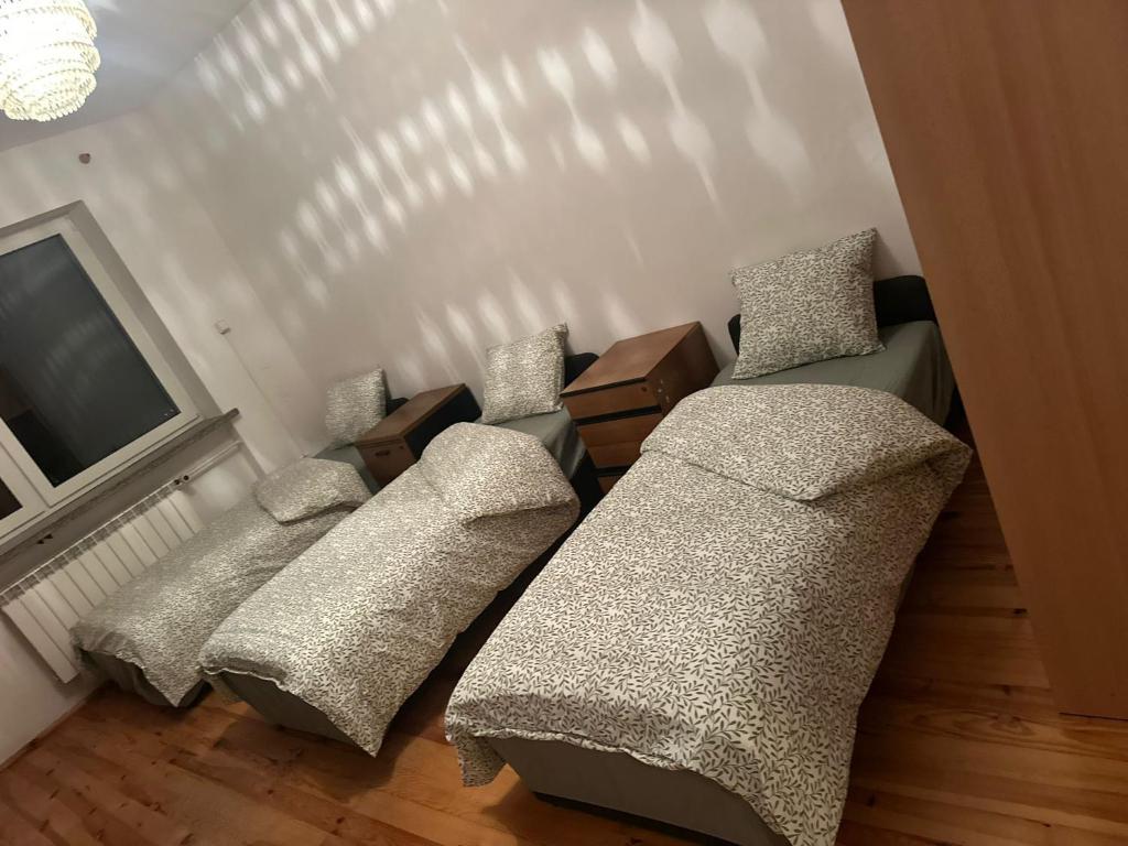 a living room with three couches and a television at CityHalo Hostel in Marki