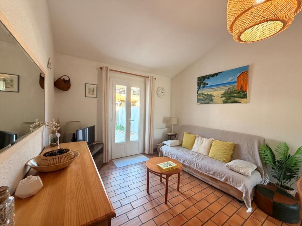 a living room with a couch and a table at Les Sables in Saint-Georges-dʼOléron