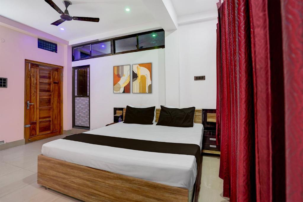 een slaapkamer met een bed en een rood gordijn bij Hotel O shreyansh in Chupra