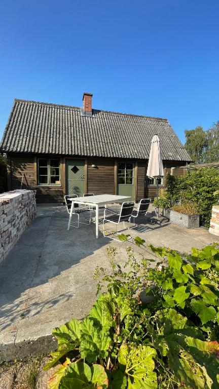 a patio with a table and chairs in front of a house at Stuga i Maglehem in Degeberga