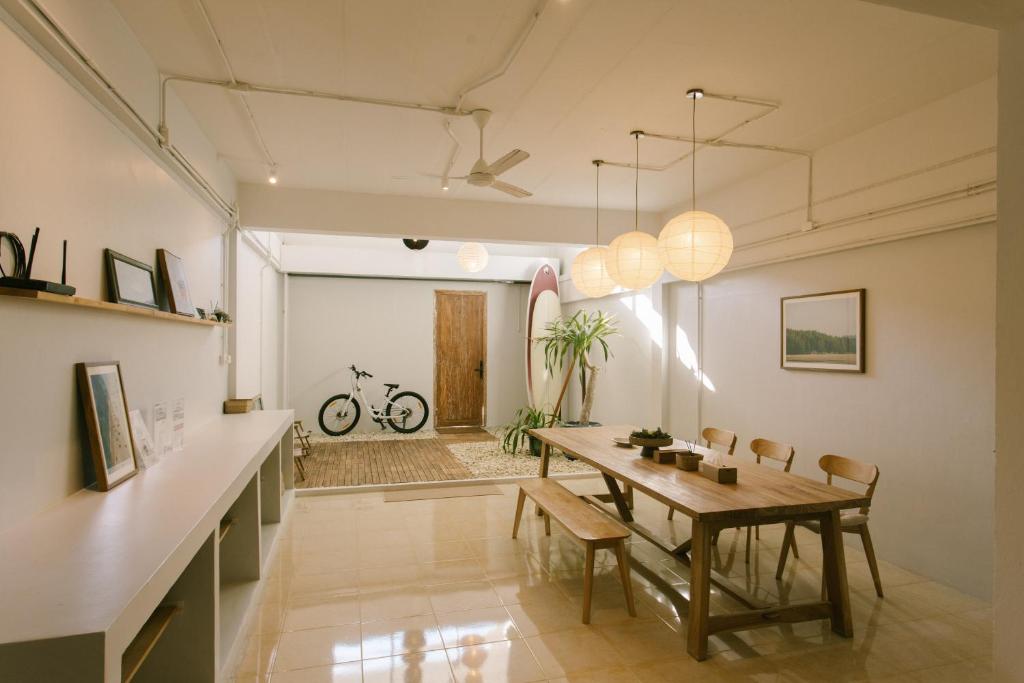 une salle à manger avec une table et un vélo en arrière-plan dans l'établissement PANI Place Khaolak, à Khao Lak