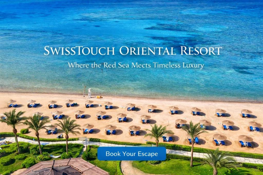 考拉亚湾Swisstouch Resort Marsa Alam的带遮阳伞和海洋的海滩鸟瞰图