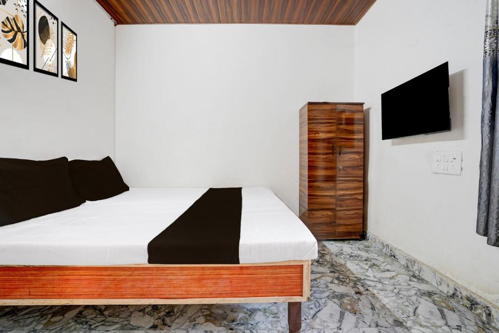 una camera da letto con un letto e una TV a parete di Hotel O Discus a Korādih