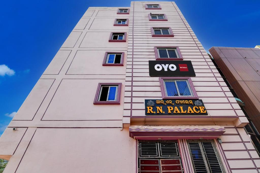 een hoog wit gebouw met een Ryan Palace-bord erop bij Hotel O RN Palace in Puri