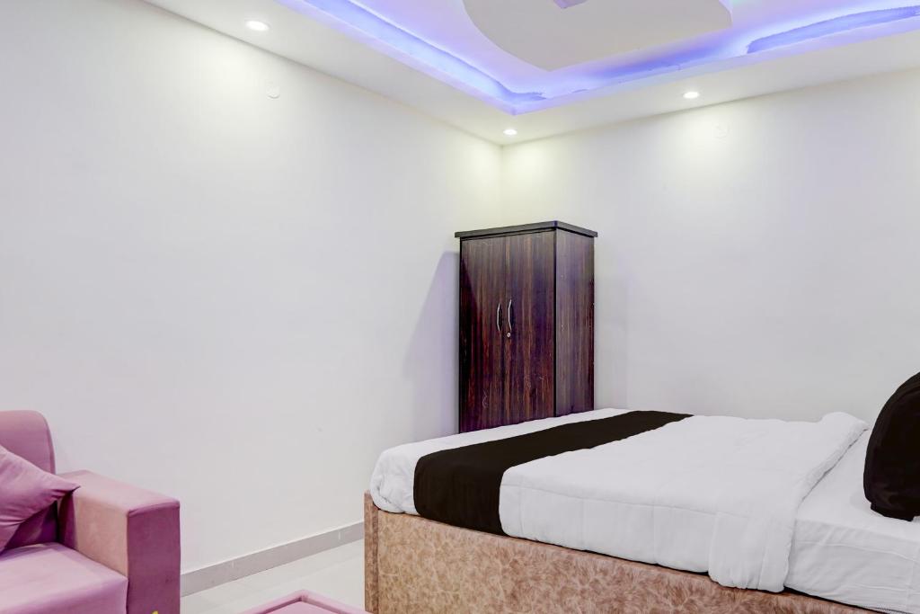 ein Schlafzimmer mit einem Bett und einem Stuhl in einem Zimmer in der Unterkunft Hotel O Royal Sangrila Inn in Dānāpur