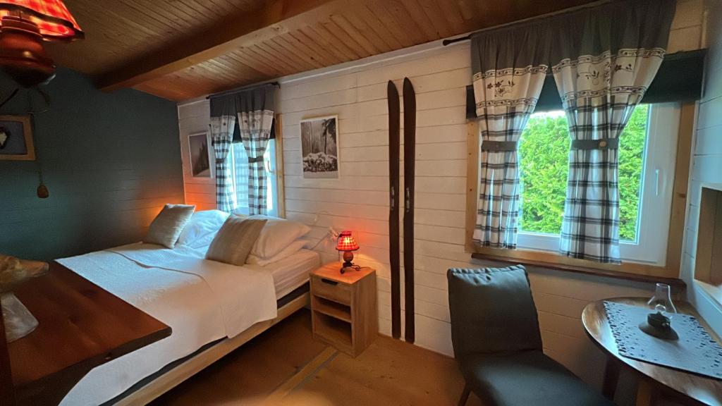 een slaapkamer met een bed, een bureau en een raam bij Die Waldstube in Bromskirchen