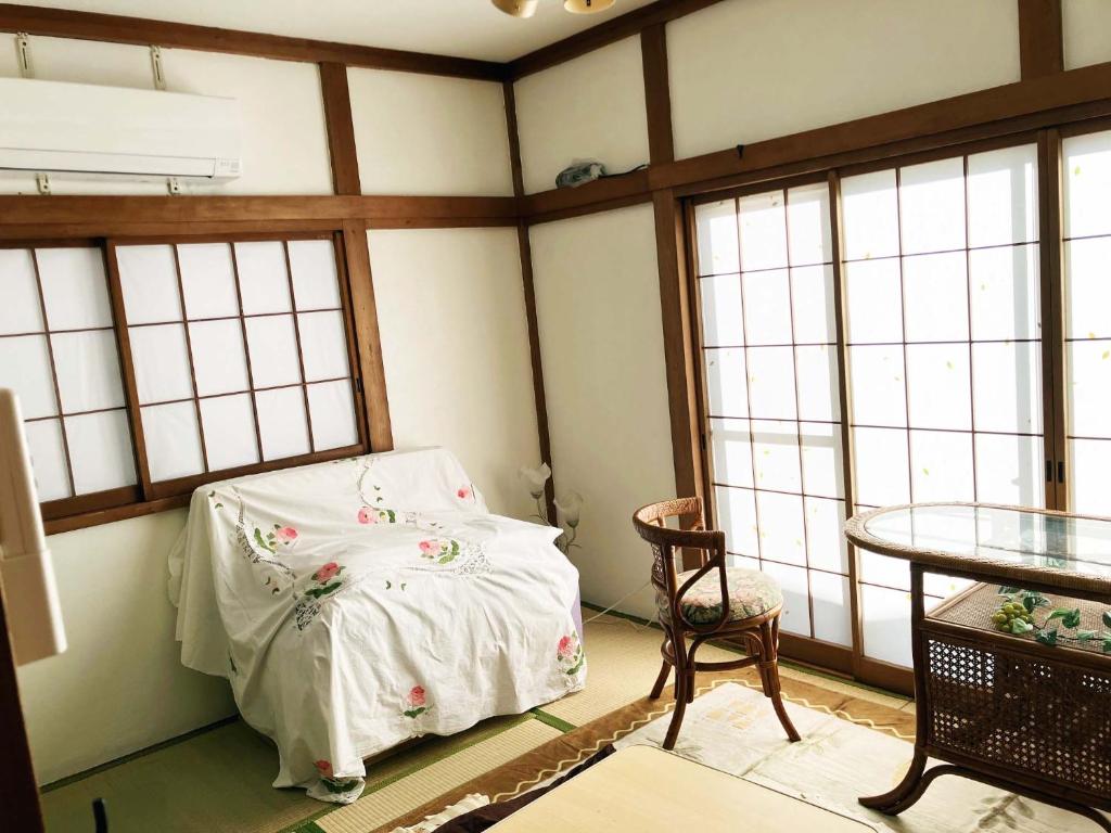 Camera con letto, tavolo e finestre di The Village House 1 a Hadano