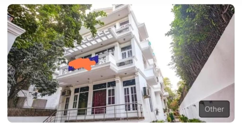 een wit gebouw met een oranje bord erop bij Hotel dev inn in Gurgaon