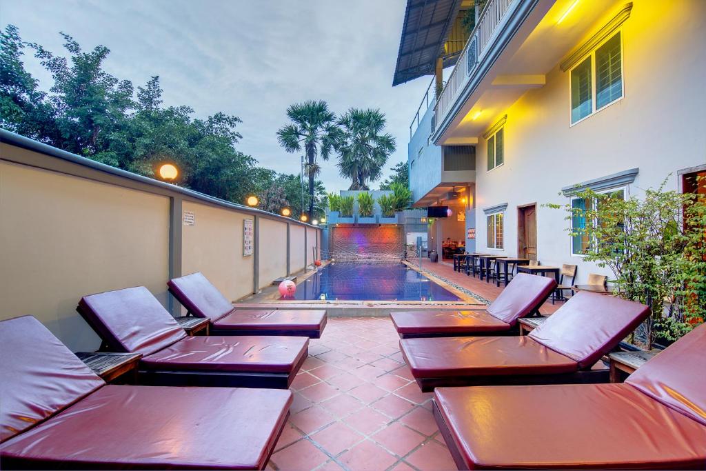 a row of benches sitting on a patio next to a building at Siem Reap Pub Hostel in Siem Reap