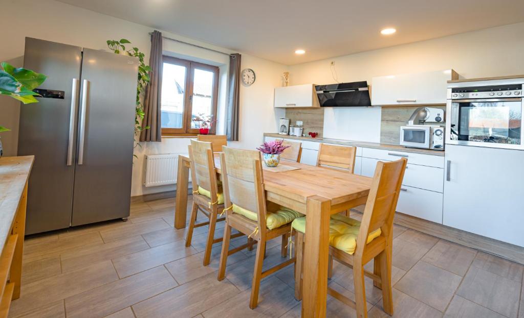 een keuken met een houten tafel en een koelkast bij FEWO 2 zur schönen Aussicht in Hinterschmiding