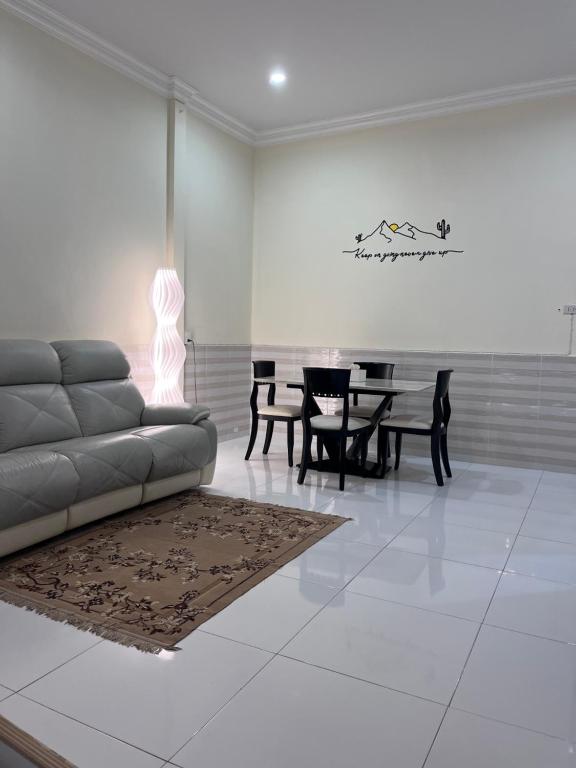 een woonkamer met een bank en een tafel bij Farwa home in Kampong Rusamileh