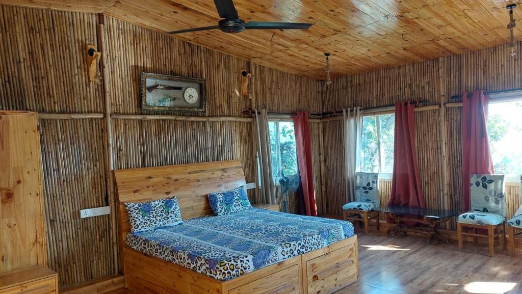 ein Schlafzimmer mit einem Bett in einem Zimmer mit Holzwänden in der Unterkunft Kutuumb Morni Hills in Morni