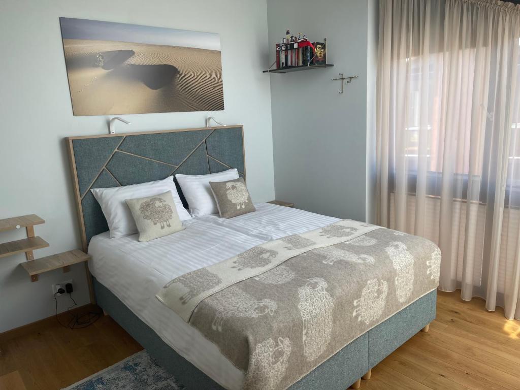 een slaapkamer met een groot bed in een kamer bij Jurmaris in Neringa