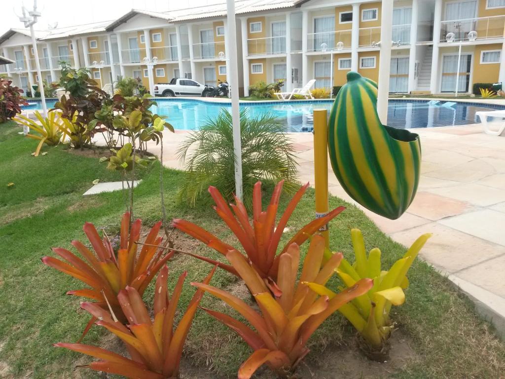 dos plantas en un patio frente a un edificio en Mont Carmelo Residencial Ap 5A Rede Tonziro, en Porto Seguro