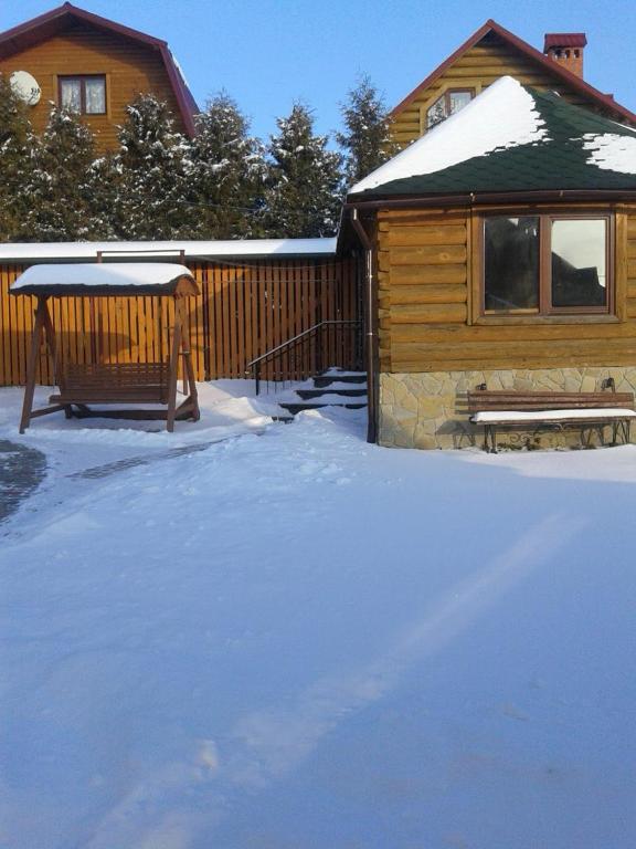 a yard covered in snow next to a house at Zolota Rybka in Skhidnitsa