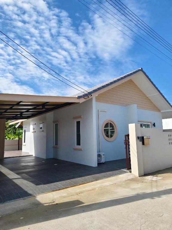 a small white house with a driveway at รักตะวัน เวียงพันแสน in Hang Dong