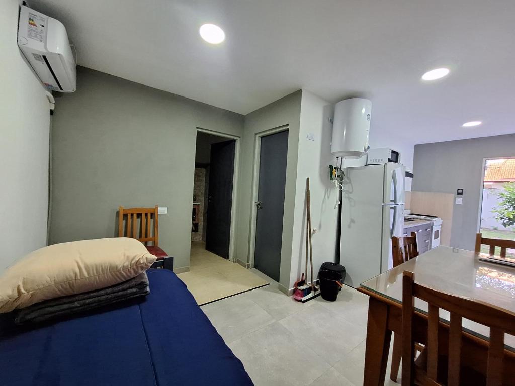 een kamer met een bed, een tafel en een keuken bij SANTA TERESITA Depto 4 personas Aire acondicionado Wifi TvCable Parrilla in Santa Teresita