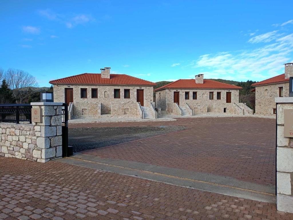 a brick parking lot with two buildings in the background at Philoxenia by nature in Karkaloú