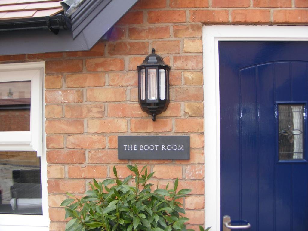 una casa de ladrillo con una puerta azul y una luz de la calle en The Manor House at Quorn, en Loughborough