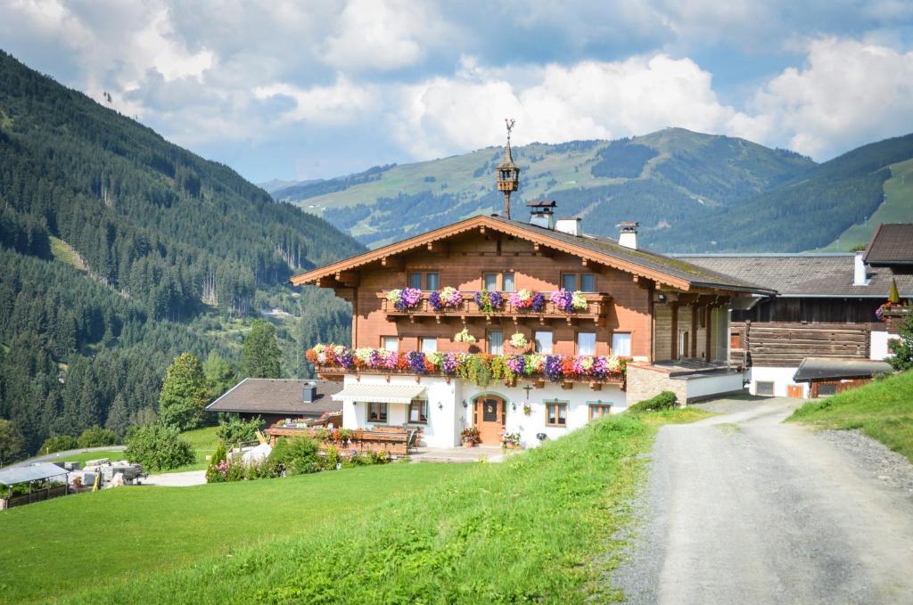 Una casa en una colina con flores. en Ferienhof Wölflbauer, en Saalbach Hinterglemm