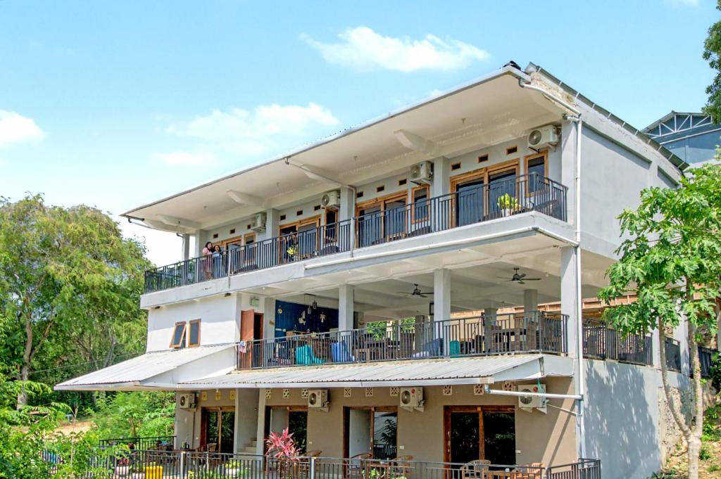 een groot wit gebouw met een balkon bij Hotel Bonne Nuit in Labuan Bajo