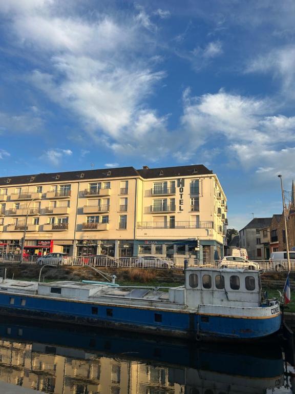 een boot in het water voor een gebouw bij Hotel le France, Redon in La Celle-sous-Gouzon