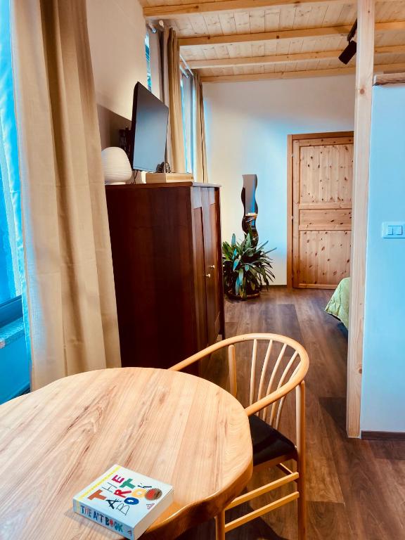 ein Wohnzimmer mit einem Holztisch und einem Fernseher in der Unterkunft primiero-suite 45mq in Transacqua
