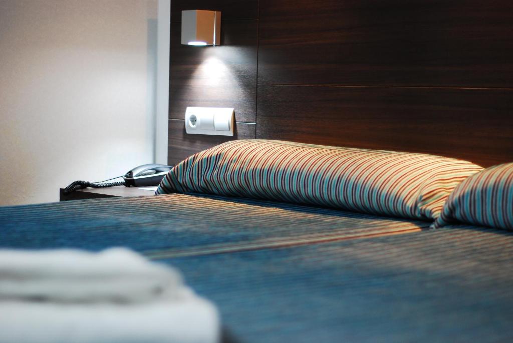 a hotel room with a bed with a wooden headboard at Hotel Porto Calpe in Calpe