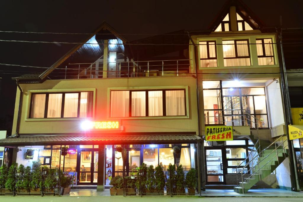 a large building with a store front at night at Casa Cojocaru in Drobeta-Turnu Severin