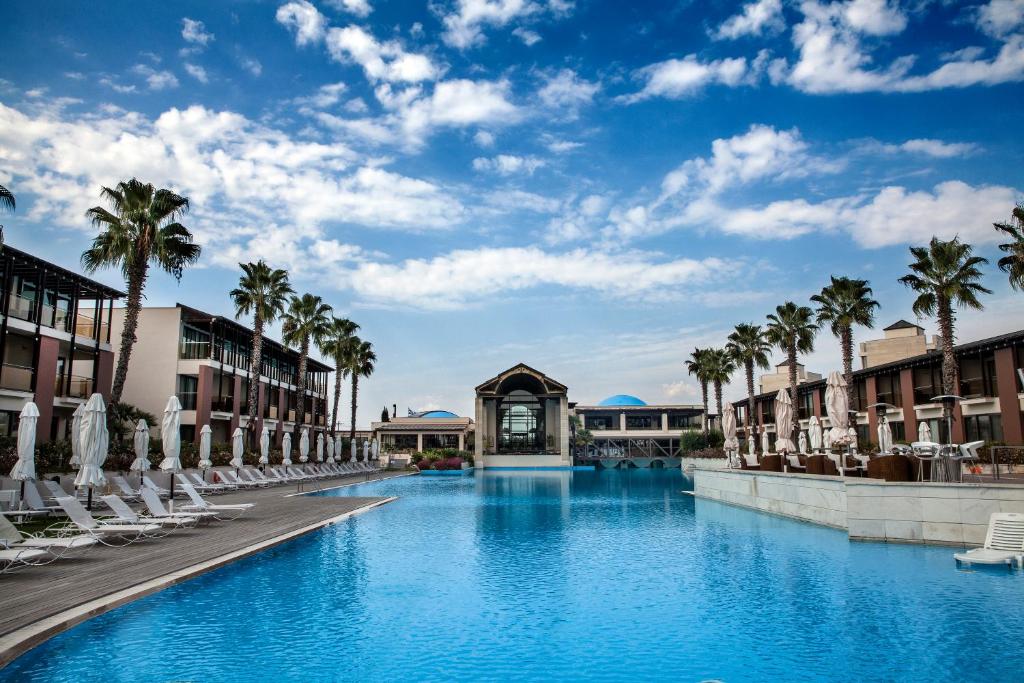 una piscina con palme e edifici di Hotel Nikopolis a Salonicco