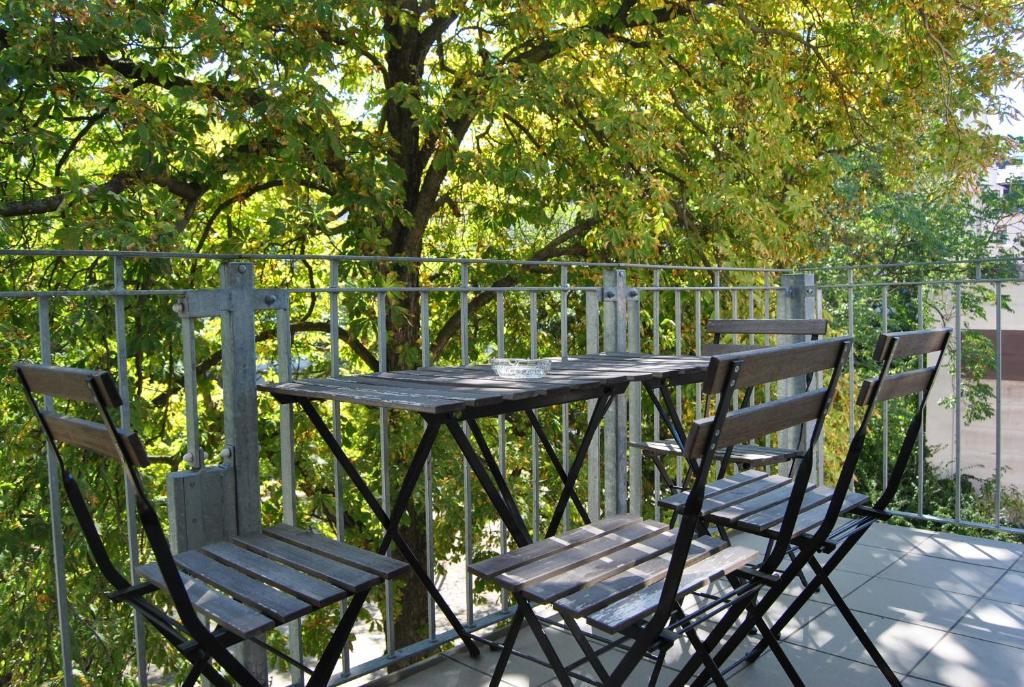 a table and two chairs sitting next to a fence at Adoreo Apartments & Suites in Leipzig