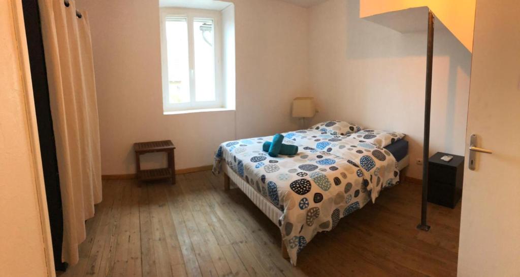 ein Schlafzimmer mit einem Bett und einem Fenster in der Unterkunft La p'tite maison in Montalieu-Vercieu