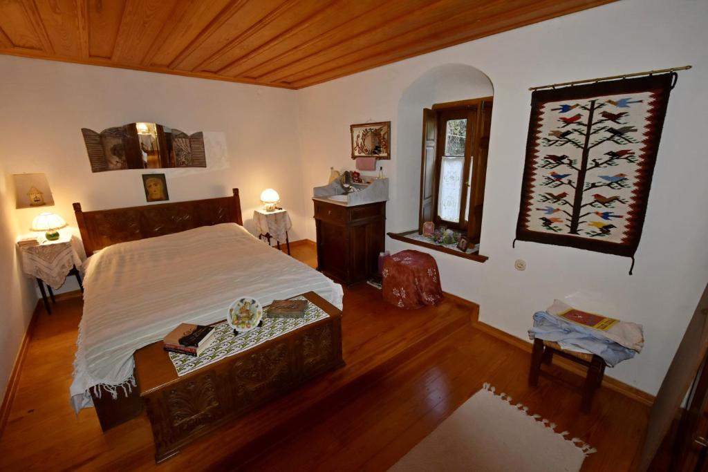 1 dormitorio con cama, mesa y ventana en Archondiko Zafeiridi en Makrinitsa