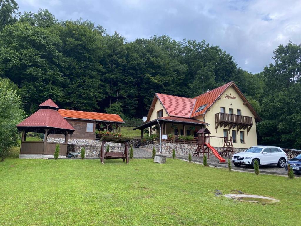 een huis met een auto ervoor geparkeerd bij Pensiunea Jazmin in Zetea