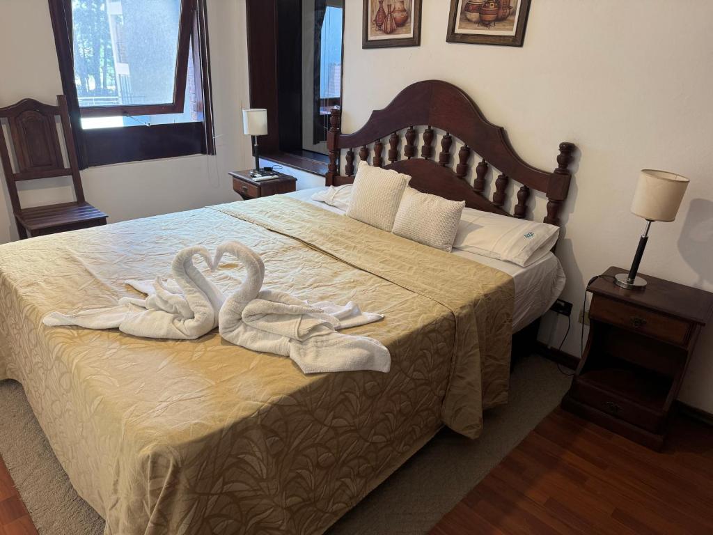 2 Schwäne Handtücher auf einem Bett in einem Schlafzimmer in der Unterkunft NOVA Hotel Pinamar in Pinamar