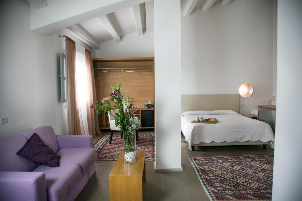 a living room with a bed and a couch at Il Vigneto Resort in Menfi