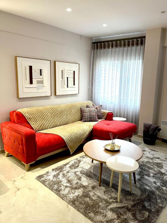 un soggiorno con un divano rosso e un tavolo di Iris Apartment II Livadeia a Levádeia