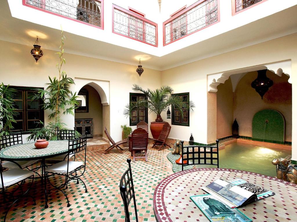 Riad Julia في مراكش: غرفة معيشة مع مسبح وطاولة وكراسي