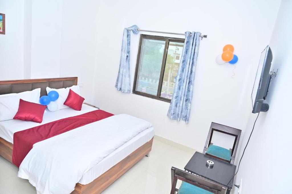 ein Schlafzimmer mit einem Bett, einem Fernseher und einem Fenster in der Unterkunft Hotel dream palace in Jodhpur