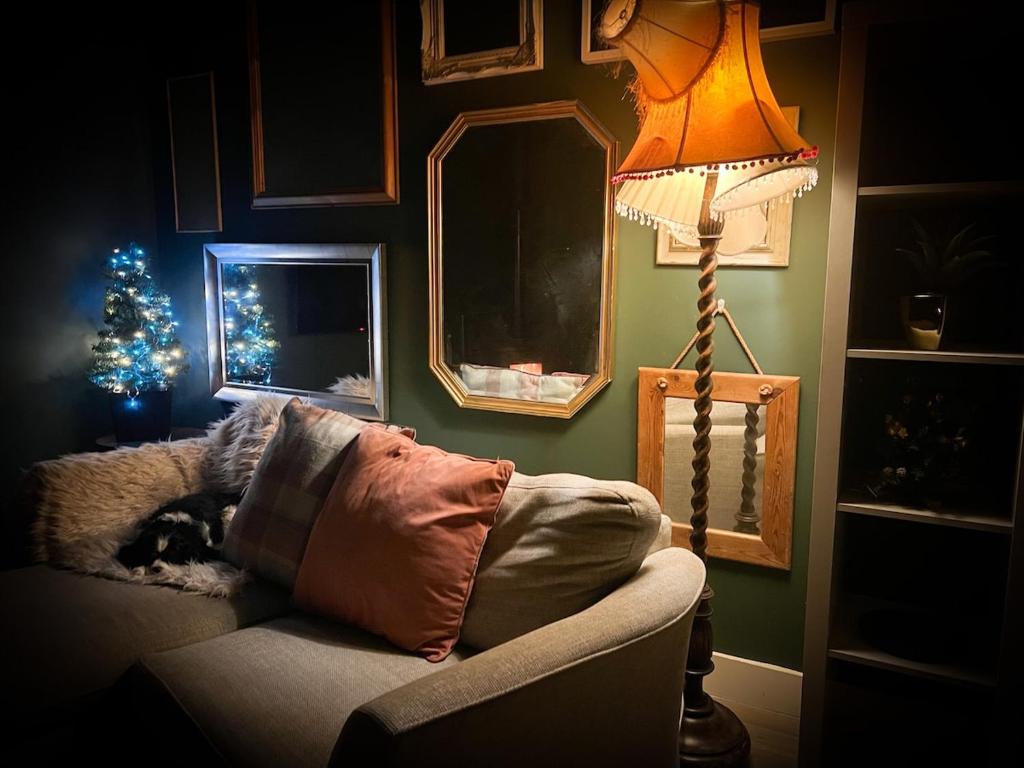 a room with a lamp and a couch with a christmas tree at The Nook at Ballyward Croft in Ardkeen