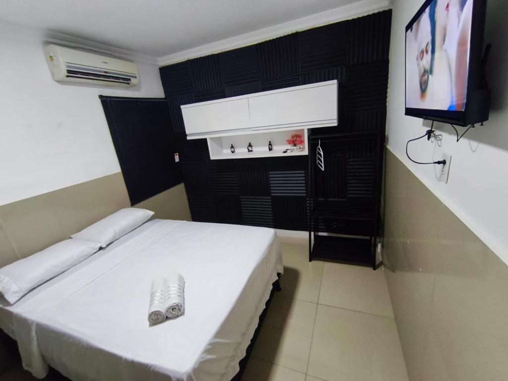 En eller flere senge i et værelse på Essenza Suites Natal