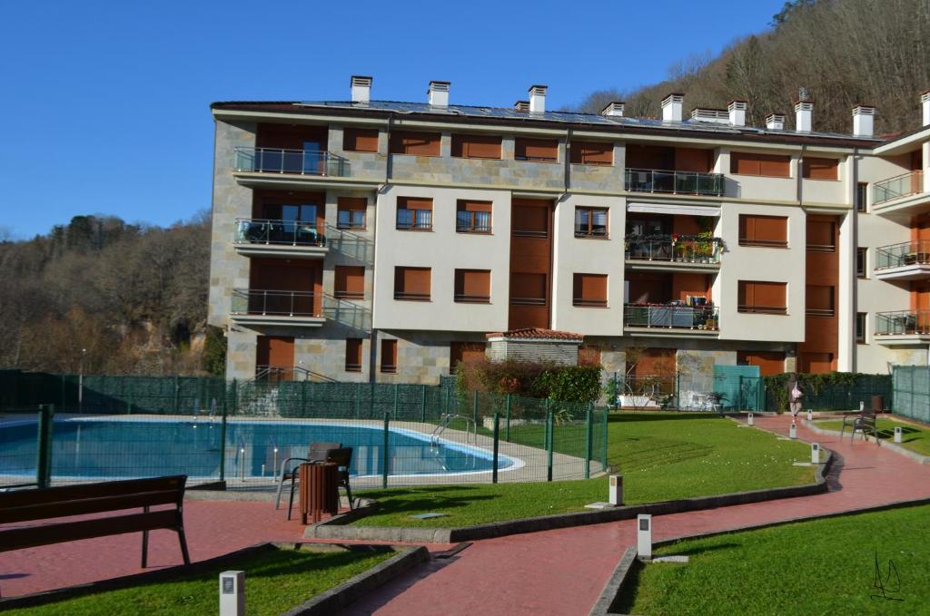 a large building with a swimming pool in front of it at JayjAstur in Cangas de Onís