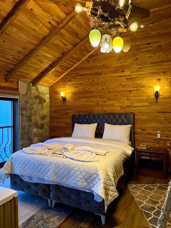 a bedroom with a bed in a wooden room at İsgobya Dağ Evleri 108 in Macka