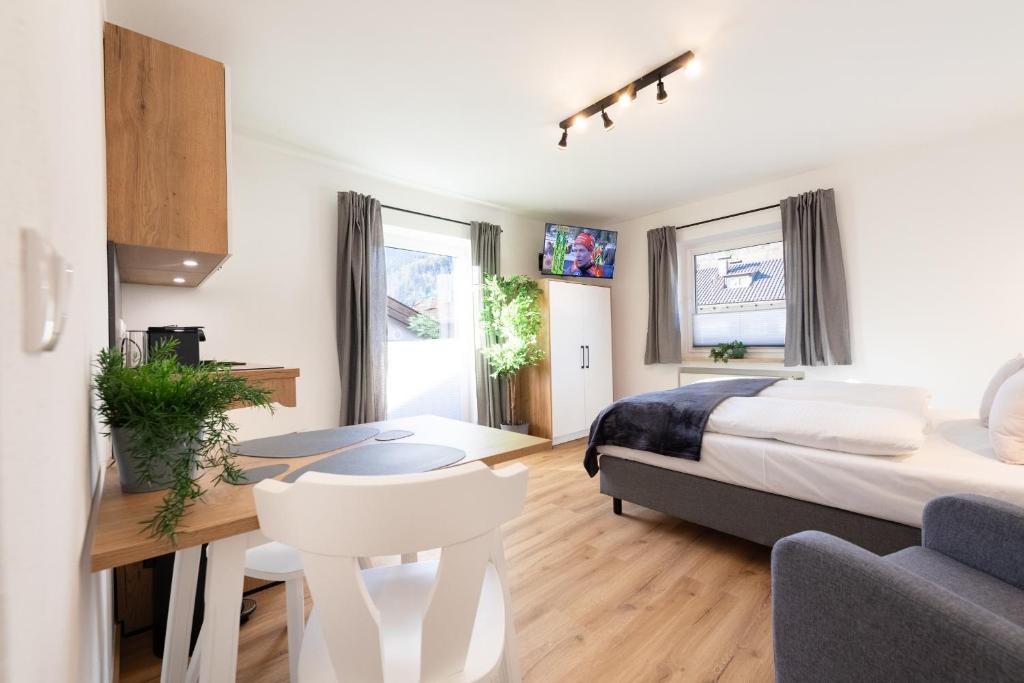 een slaapkamer met een bed, een bureau en een bank bij Heu22 Sommerfrische in Farchant