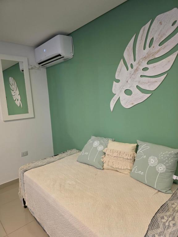a bedroom with a bed and a wall with a fan at Peperina 2 villa Carlos paz in Villa Carlos Paz