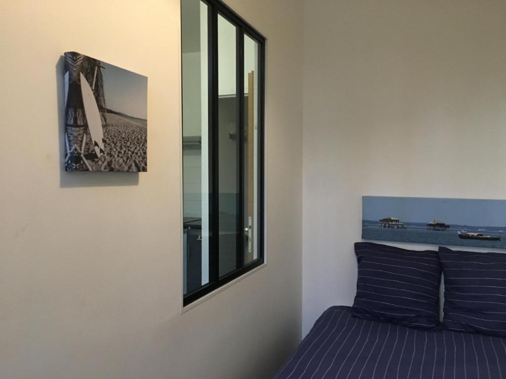 een slaapkamer met een spiegel en een bed bij Petit T2 de charme in Eysines