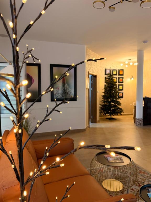 a living room with a tree with christmas lights at A-Termal Palić in Palić