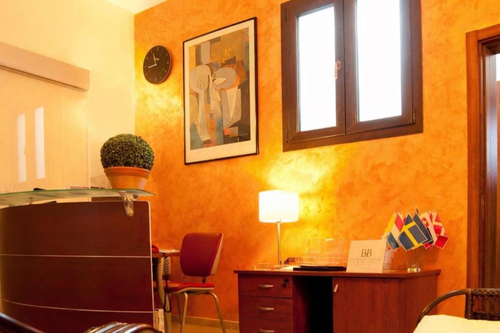 een oranje kamer met een bureau en een raam bij La Corte degli Spada - Borgo Antico del Salento in Mesagne